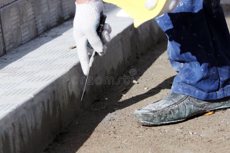 tiler processes the surface for laying the stone tiles on the steps in the repair of the office building. royalty free stock photo