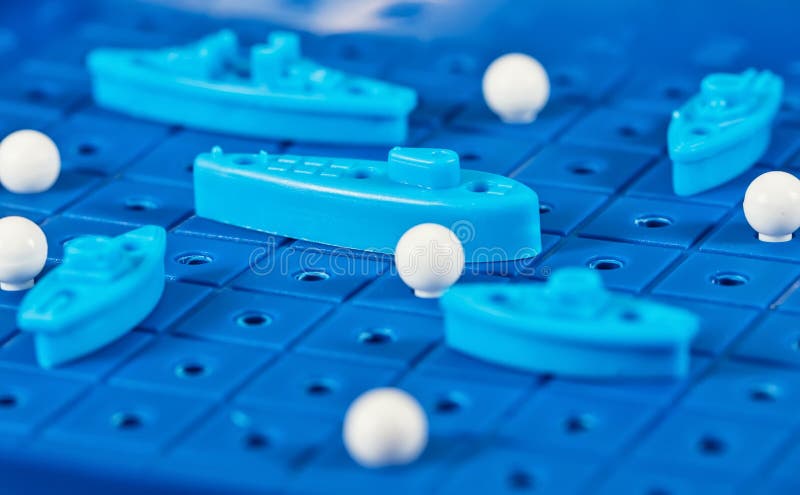 Toy war ships and submarine are placed on the blue playing Boar. Toy war ships and submarine are placed on the playing Board in the game battleship royalty free stock photo