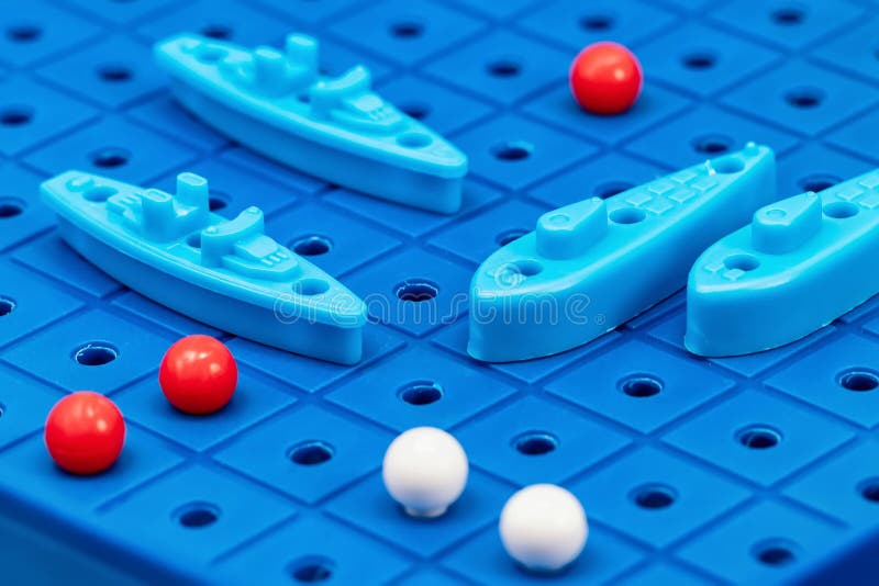 Toy war ships and submarine are placed on the blue playing Board. Toy war ships and submarine are placed on the playing Board in the game battleship royalty free stock photography