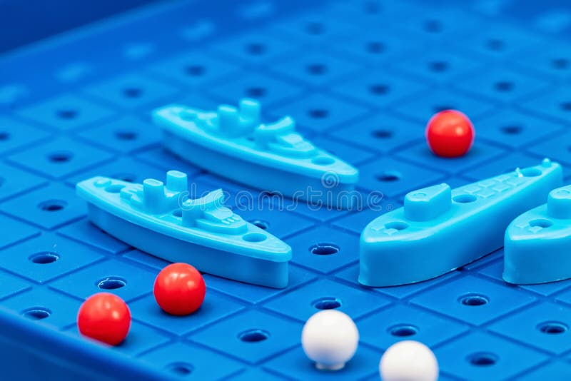 Toy war ships and submarine are placed on the blue playing Board. Toy war ships and submarine are placed on the playing Board in the game battleship stock image