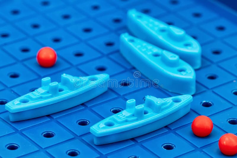 Toy war ships and submarine are placed on the blue playing Board. Toy war ships and submarine are placed on the playing Board in the game battleship stock photo