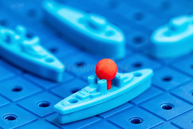 Toy war ships and submarine are placed on the blue playing Board. Toy war ships and submarine are placed on the playing Board in the game battleship royalty free stock images