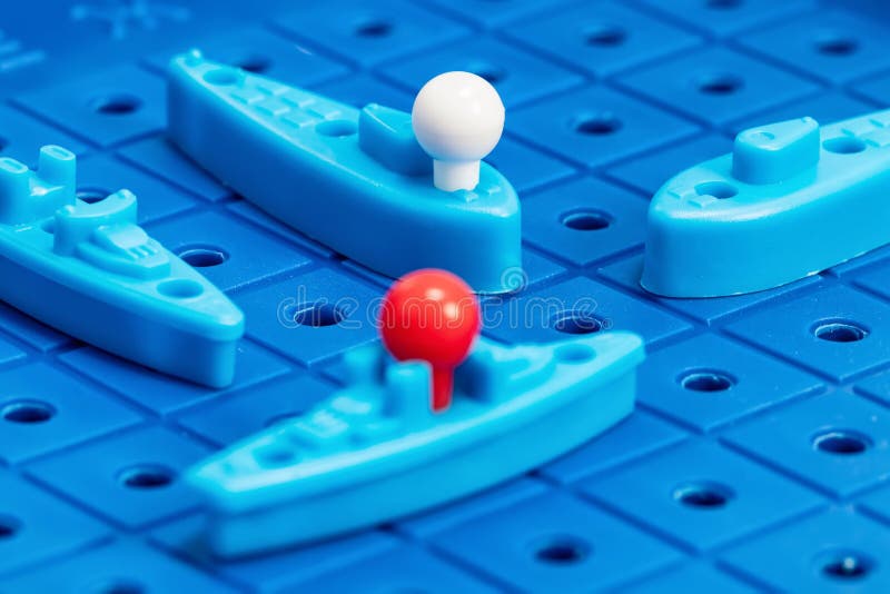 Toy war ships and submarine are placed on the blue playing Board. Toy war ships and submarine are placed on the playing Board in the game battleship stock photography