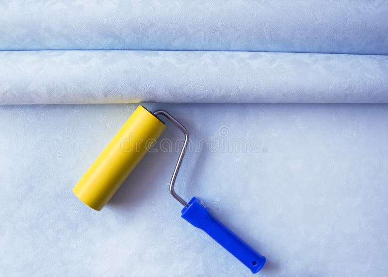 Two rolls of blue Wallpaper and a roller for home repair and renovation. Flat position, top view, copy space -Image royalty free stock photography