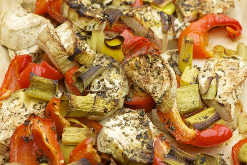 Vegetables mix baked in the oven with aubergine, red bell pepper, leek, basil and olive oil. stock image