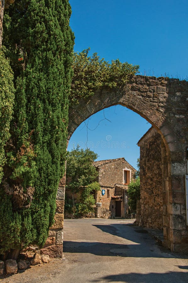 View of stone wall and arch under sunny blue sky at Les Arcs-sur-Argens. View of stone wall and arch under sunny blue sky at the entrance of the lovely Les Arcs stock photo