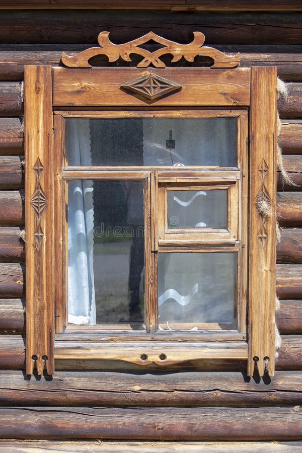 Window with carved platbands in an old wooden house. Front view royalty free stock photo
