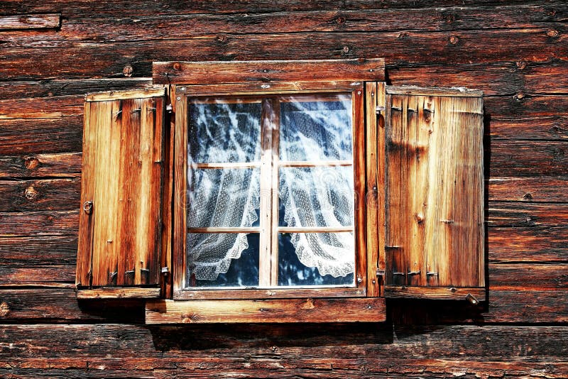 Windows with curtains and shutters on an old wooden house stock photos