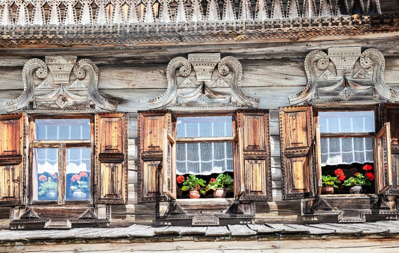 Windows of old Russian log house with carved wooden platbands royalty free stock photography