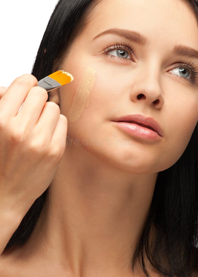 Woman applying foundation stock images