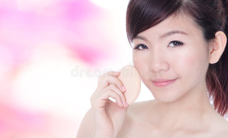 Woman applying foundation on face royalty free stock images