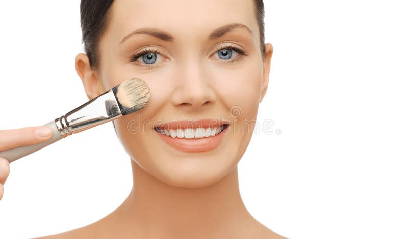 Woman applying liquid foundation with brush royalty free stock photo