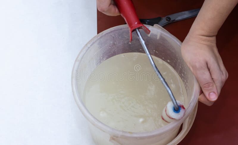 Woman with Wallpaper and roller, glue in a bucket. Woman with Wallpaper and roller, glue in bucket for work stock images