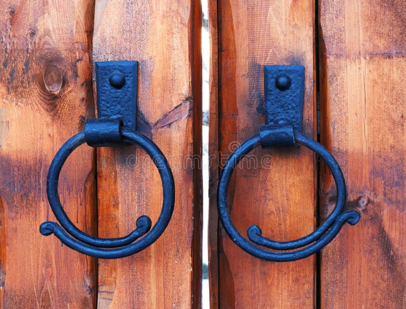 Wooden castle gate. Cast iron antique door handle ring on wood door. royalty free stock photography