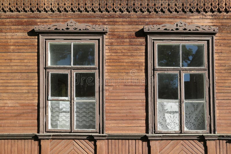 wooden windows with carved platbands and carved eaves in a village house royalty free stock photo