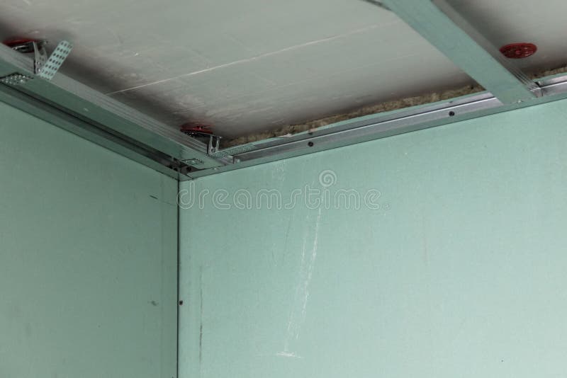 Worker fastens a metal profile to the ceiling. Repair of a room in the house royalty free stock photography