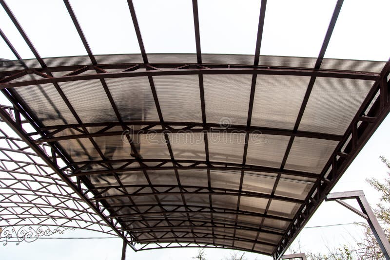 A worker mounts a metal canopy in the courtyard of the house. Silhouette man bottom view stock image