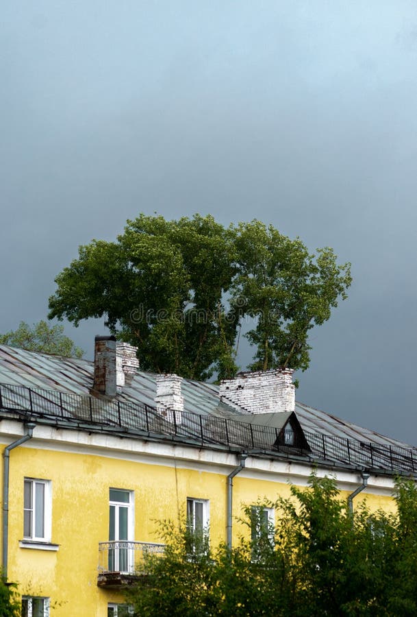 Yellow house on a background of a stormy sky. Yellow house with a sloping roof against a stormy sky in front of a strong thunderstorm stock photos