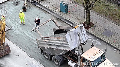 Construction excavator taking asphalt back and forth on the road stock video