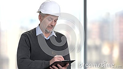 Mature foreman making a note on clipboard. stock video