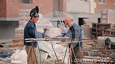 Two builders welds the pipe to the construction stock footage